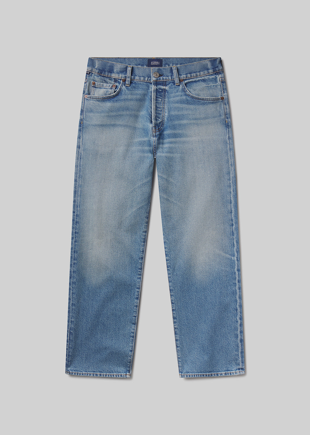 Flat lay of a pair of blue jeans on a grey background