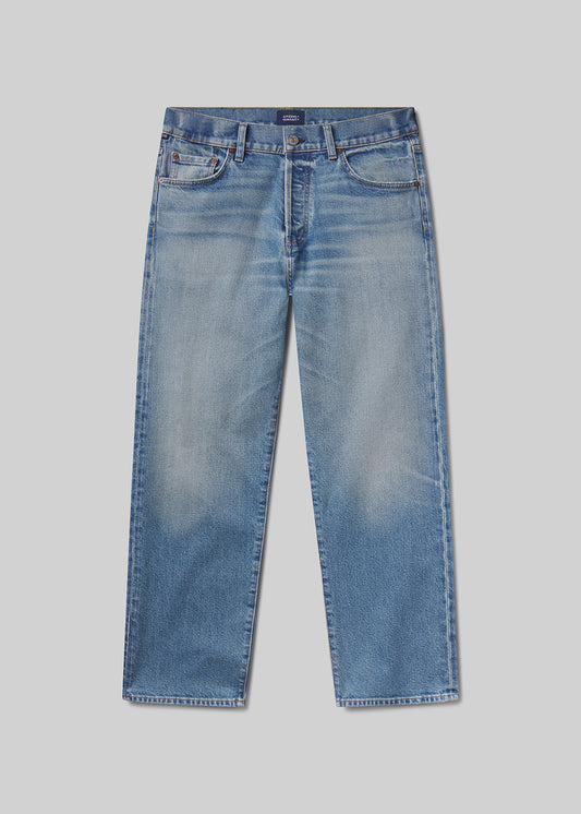 Flat lay of a pair of blue jeans on a grey background
