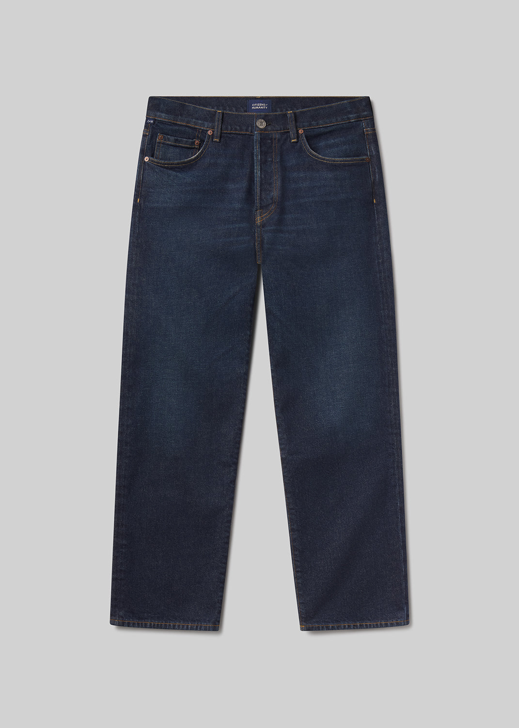 Flat lay shot of a pair of dark blue jeans on a grey background