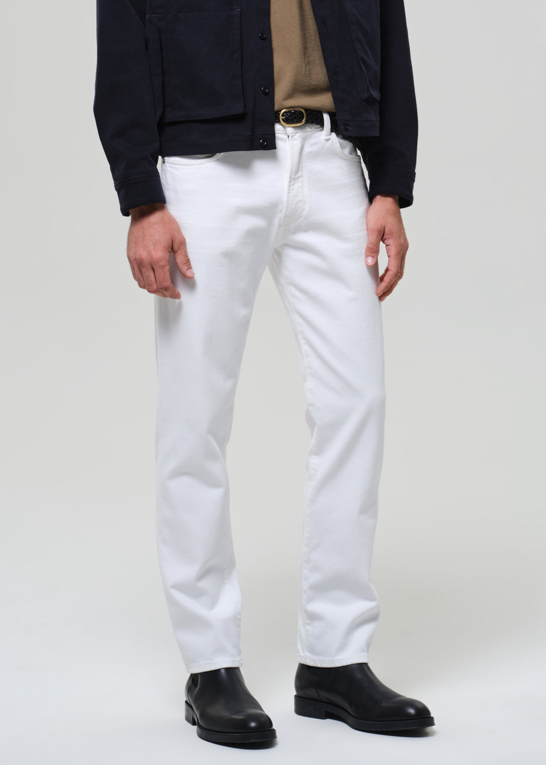 Person wearing white jeans with a plain background