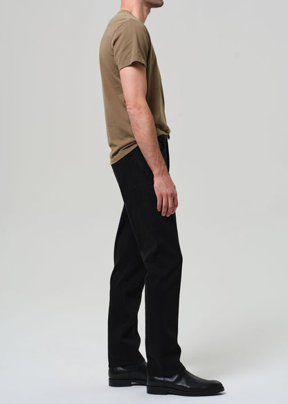 Person wearing a brown t-shirt and black pants on a white background