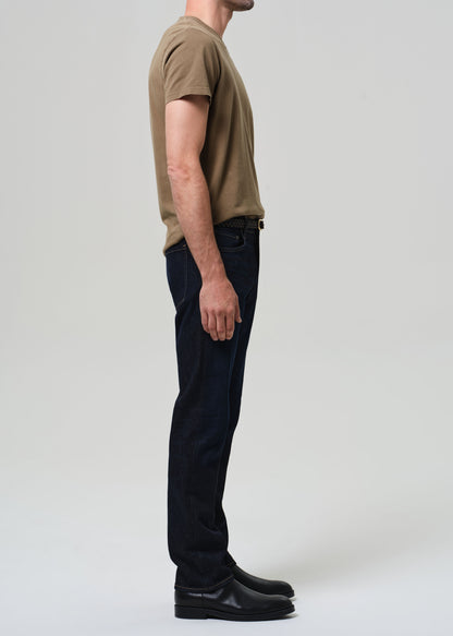 Person wearing a brown t-shirt and black pants on a plain background