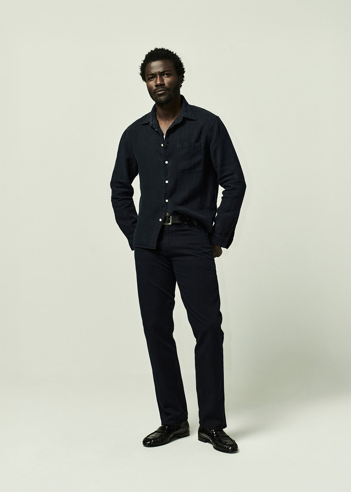Man wearing a navy shirt and pants on a plain background