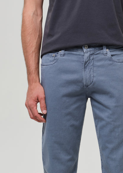 Person wearing a dark gray t-shirt and blue pants on a plain background