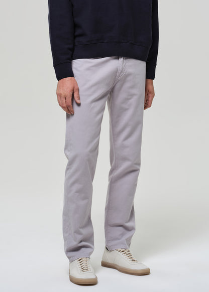 Person wearing a navy poly and light gray pants on a plain background