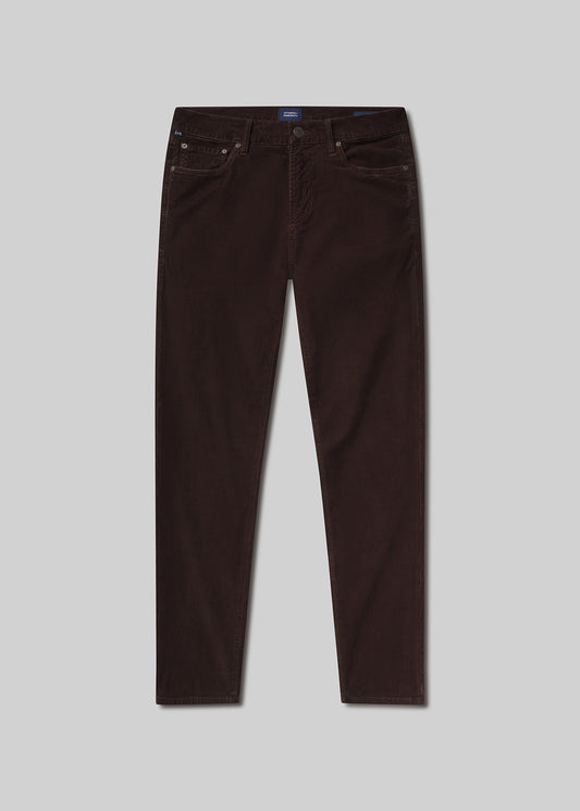 Flat lay of brown jeans on a light grey background