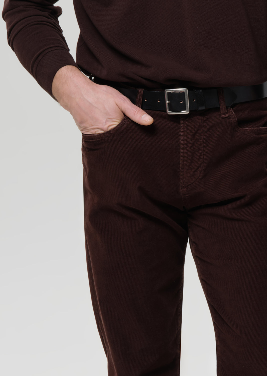 Brown pants worn by a person on a grey background