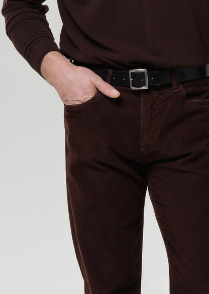 Brown pants worn by a person on a grey background