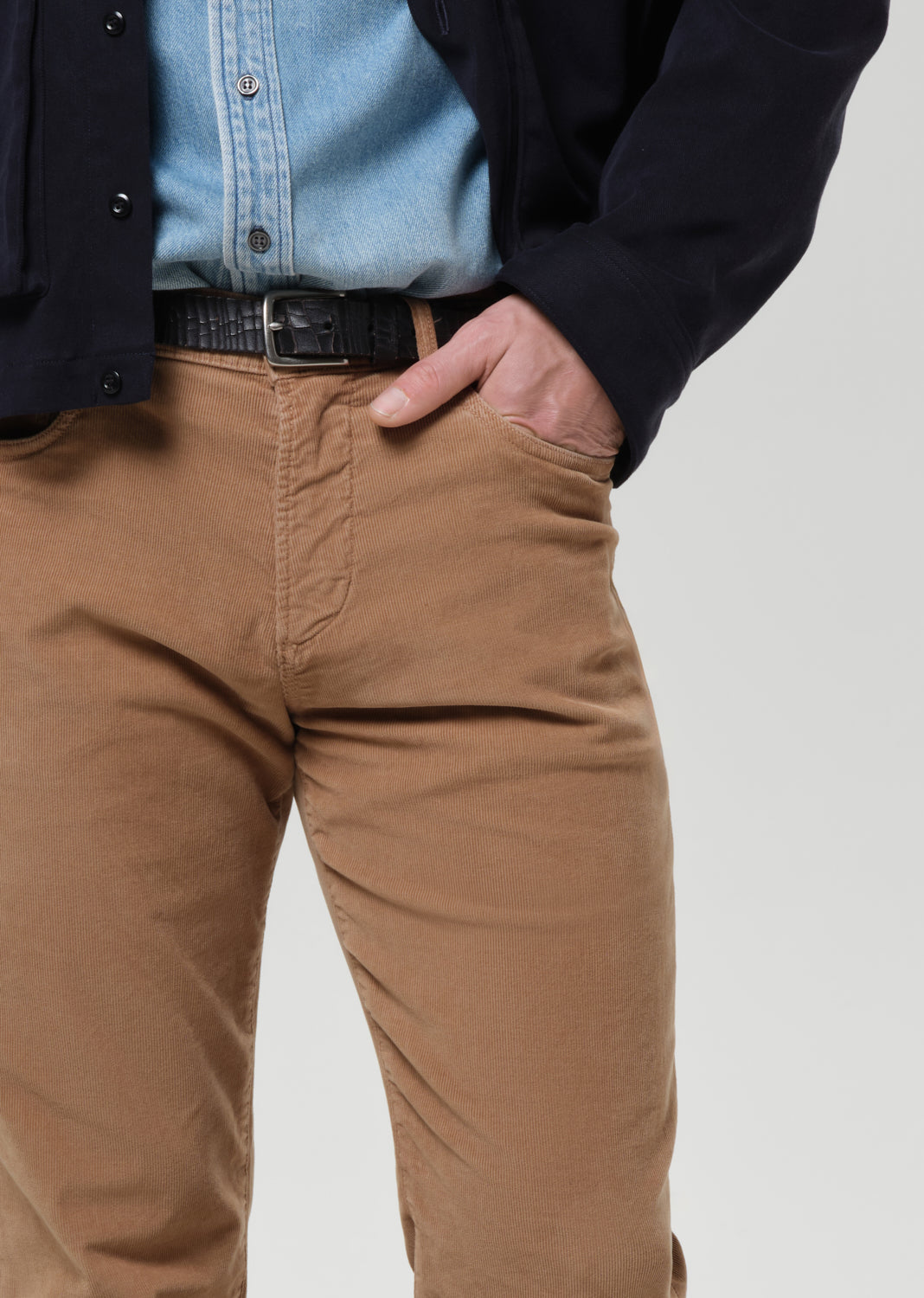 Person wearing brown pants with a grey background