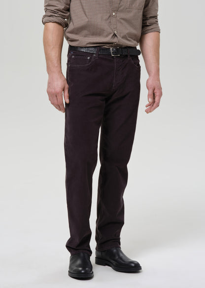 Person wearing dark grey pants and a patterned shirt on a grey background