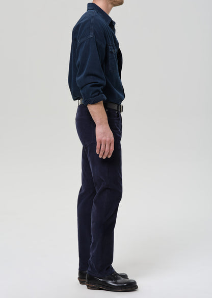 Person wearing a navy blue shirt and pants on a grey background