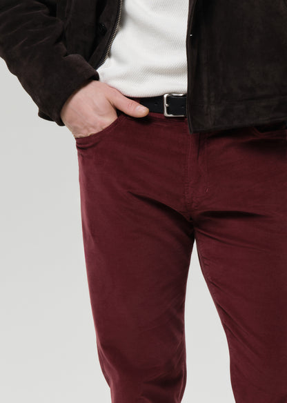 Maroon pants worn by a person on a grey background