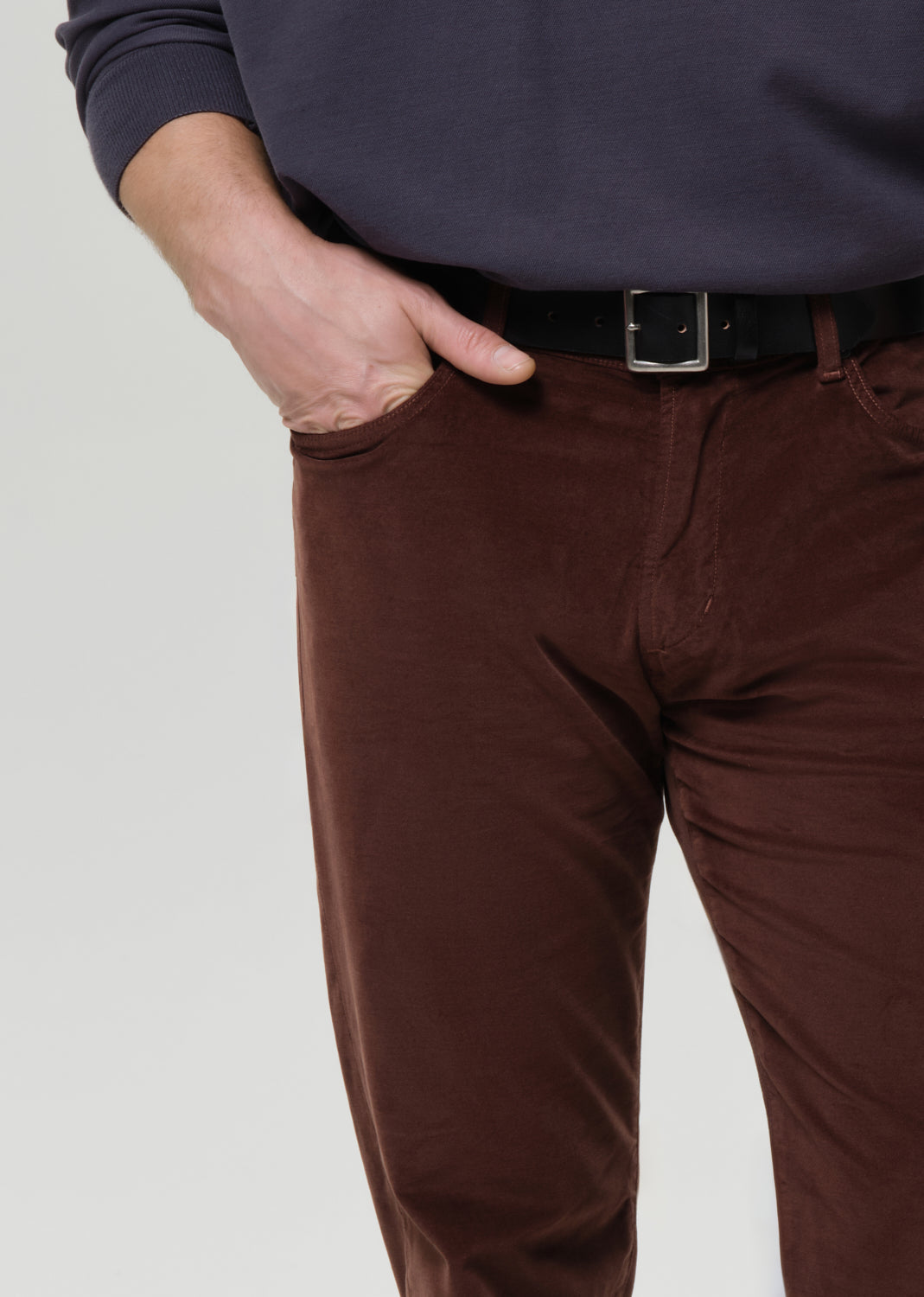Brown pants worn by a person on a grey background