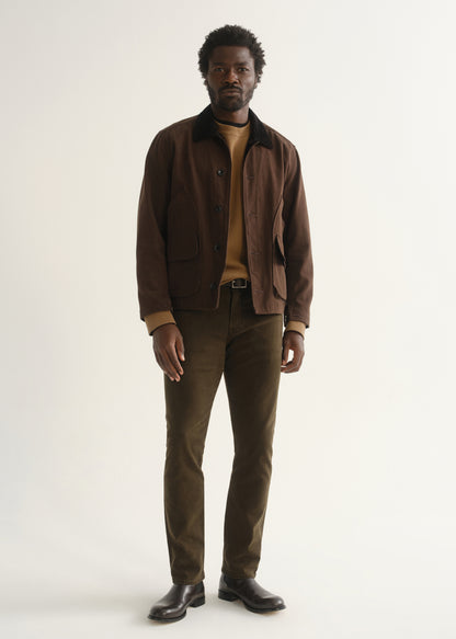 Person wearing dark brown straight leg pants with a brown jacket, dark shirt, and black shoes, front full body view on a light grey background.