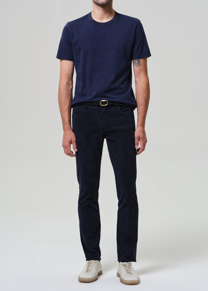 Person wearing a navy t-shirt and dark pants on a white background