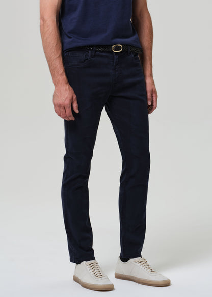 Person wearing navy blue jeans and a dark shirt on a plain background