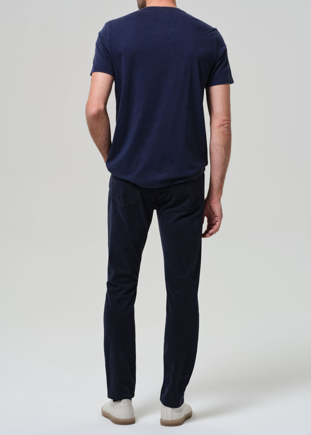 Person wearing a navy blue t-shirt and pants on a white background