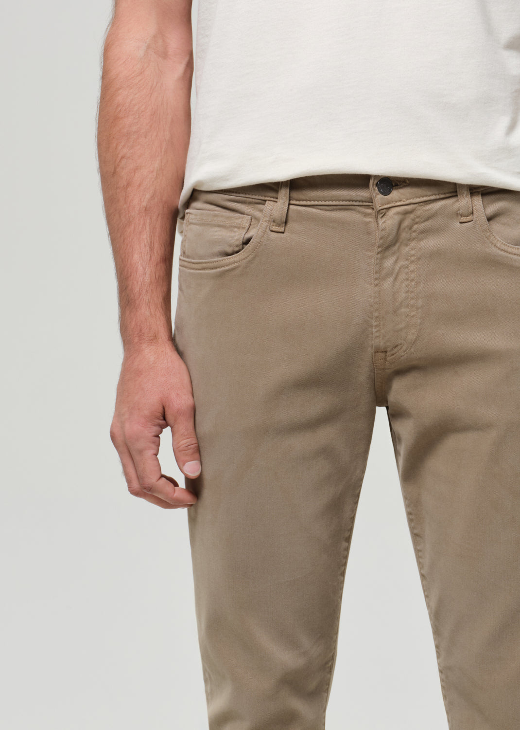 Beige pants worn by a person on a plain background