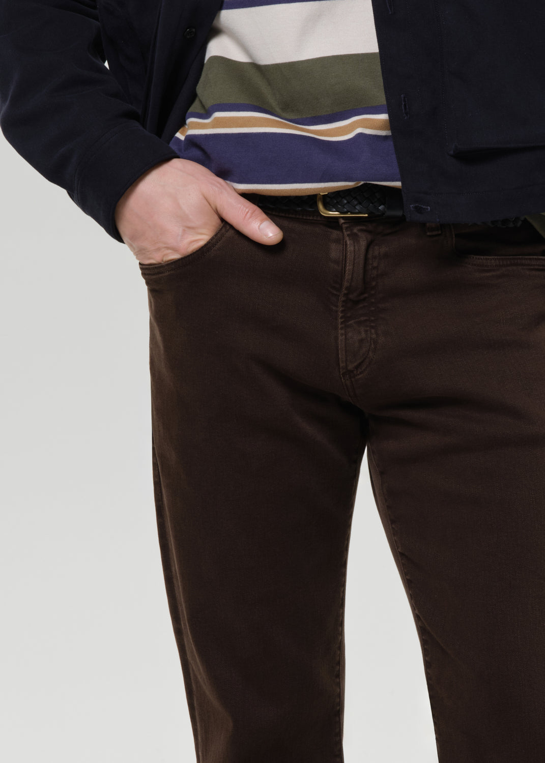 Brown pants worn by a person on a grey background