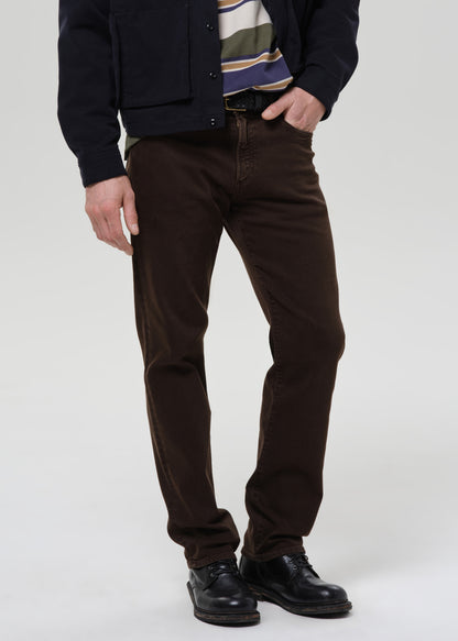 Person wearing brown pants and a dark jacket on a grey background