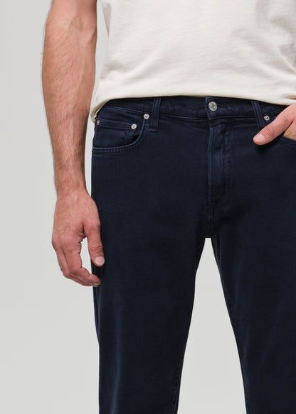 Navy blue jeans worn by a person on a light gray background