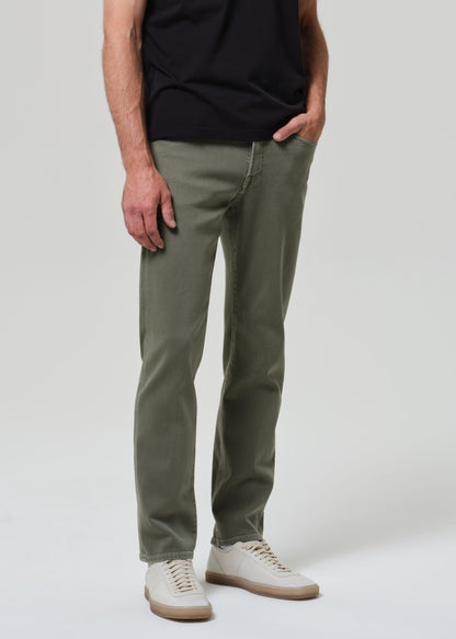 Person wearing olive green pants and a black shirt on a white background