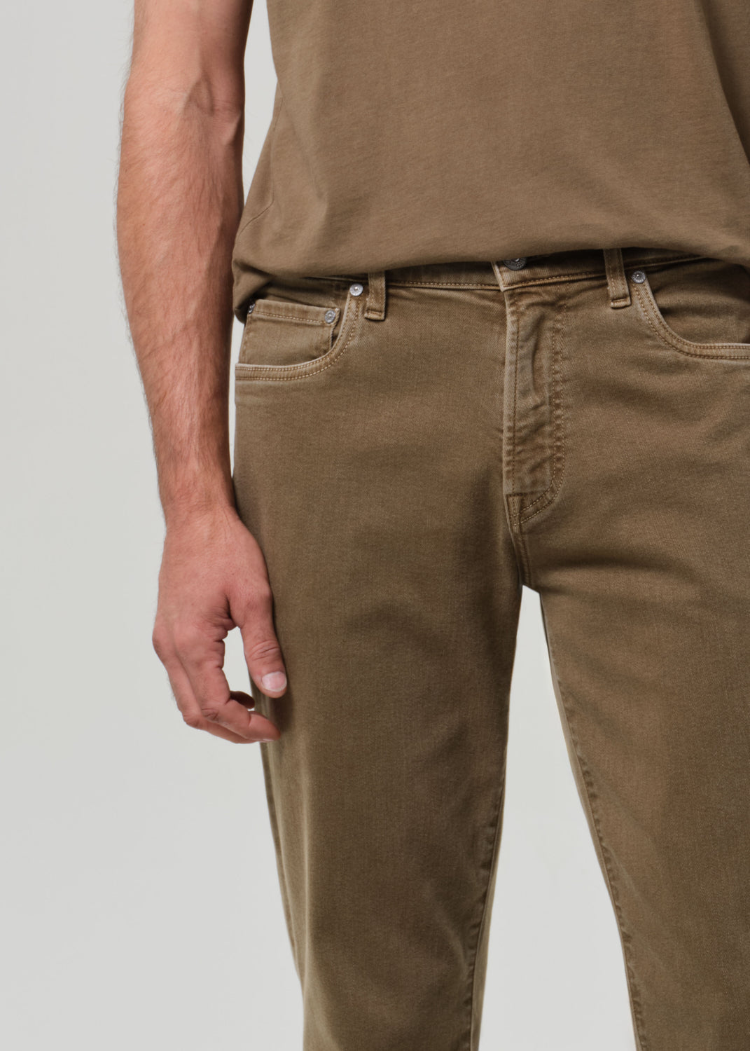 Person wearing brown pants and a matching shirt on a plain background
