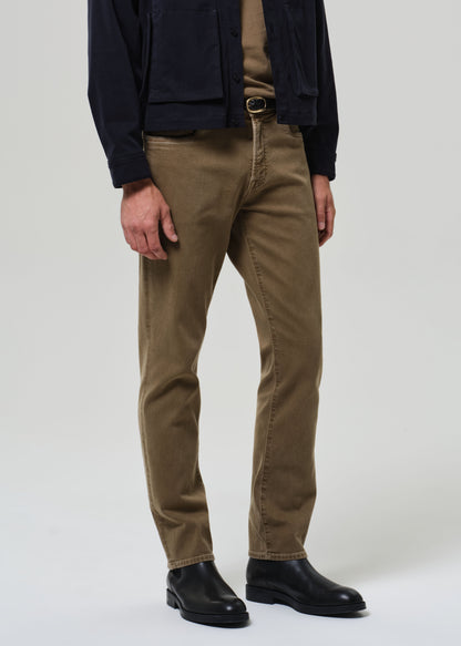 Person wearing brown pants and black shoes on a white background