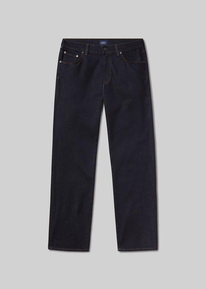 Flat lay of a pair of dark blue jeans on a light grey background