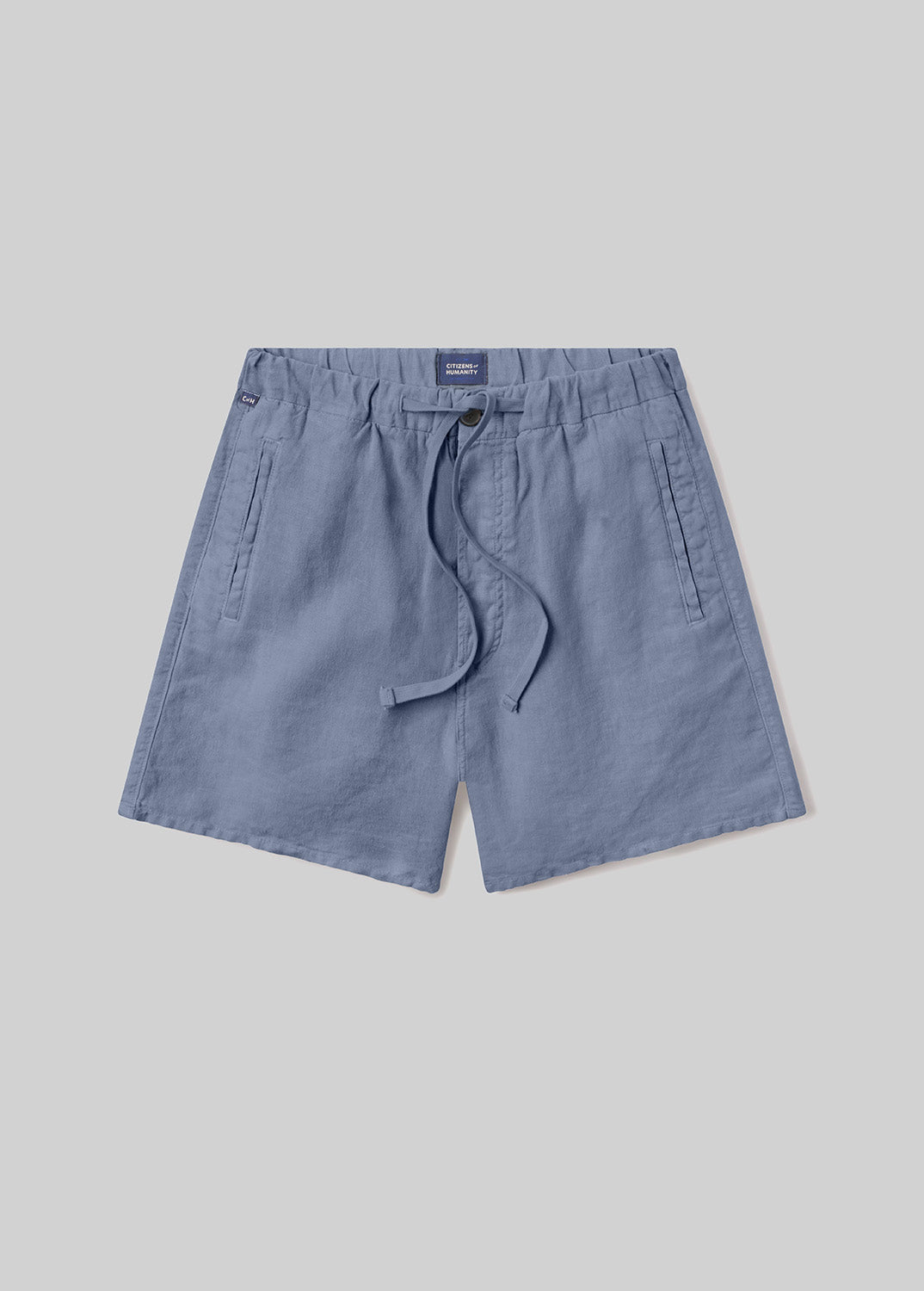 Stone blue drawstring shorts with an elastic waistband, adjustable drawstring, and side pockets, front flat lay view on a grey background.