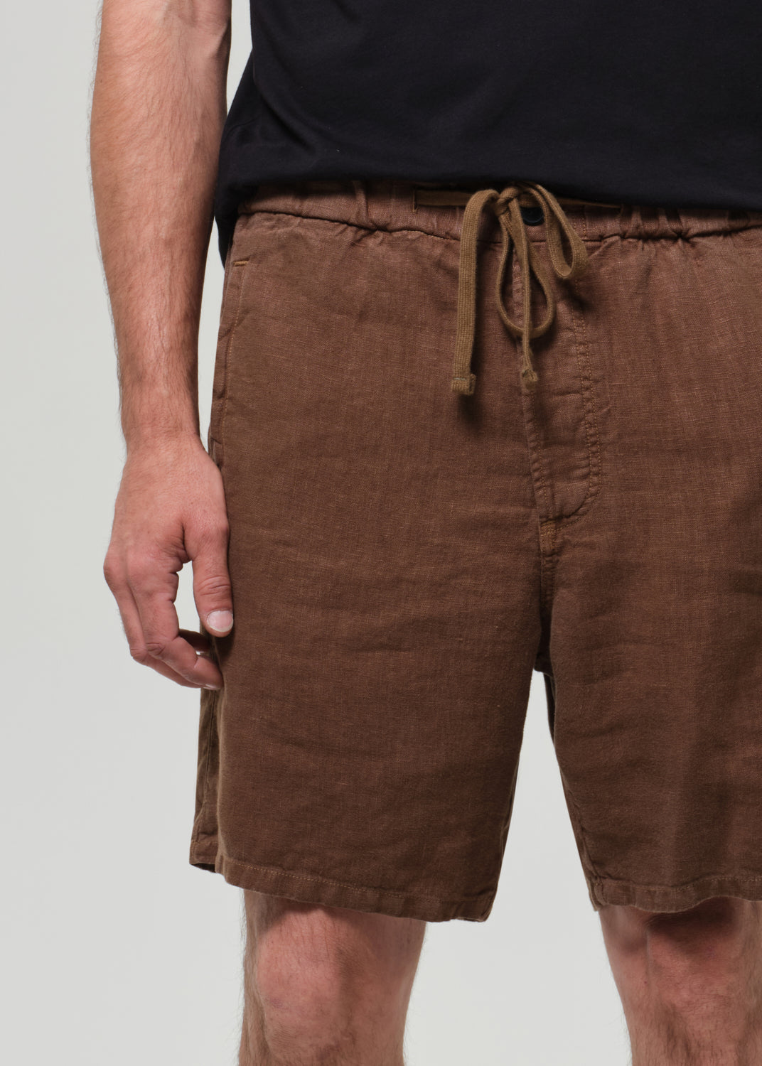 Brown shorts with a drawstring on a plain background