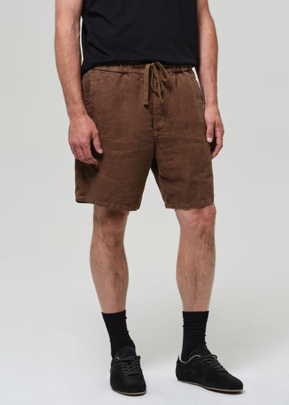 Person wearing brown shorts on a grey background