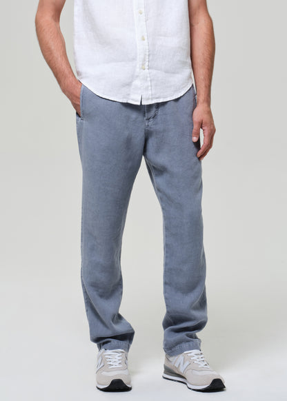 Person wearing light blue jeans and a white shirt on a plain background