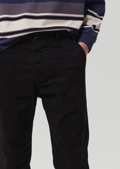 Person wearing black pants and a striped sweater on a plain background