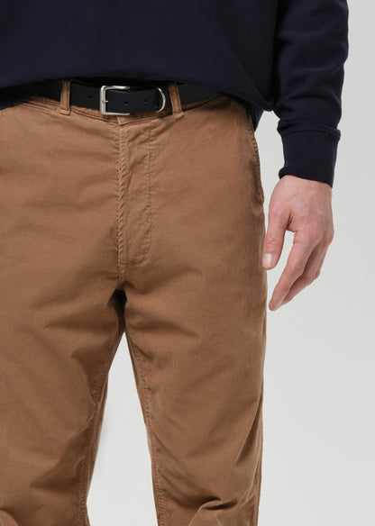 Brown pants worn by a person on a grey background