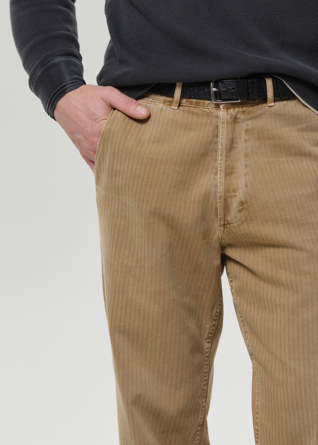 Person wearing brown corduroy pants with a grey background