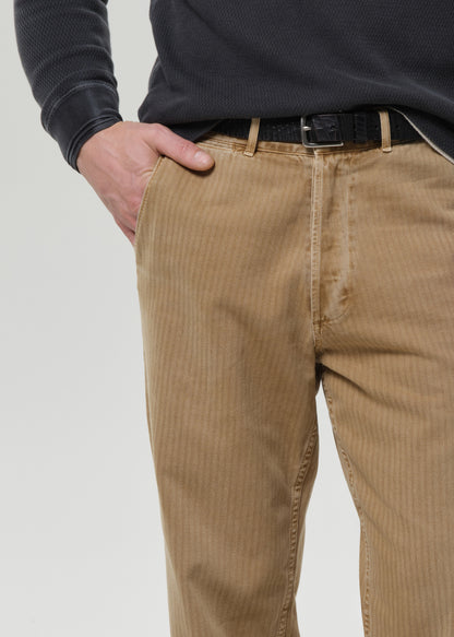 Person wearing brown corduroy pants with a grey background