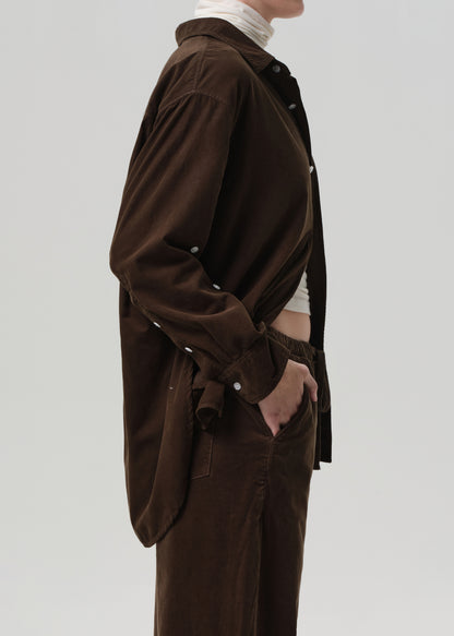 Brown shirt worn by a person on a plain background