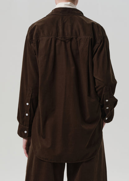 Brown shirt with white buttons on a plain background