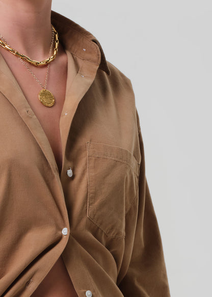 Brown corduroy shirt worn by a person on a grey background