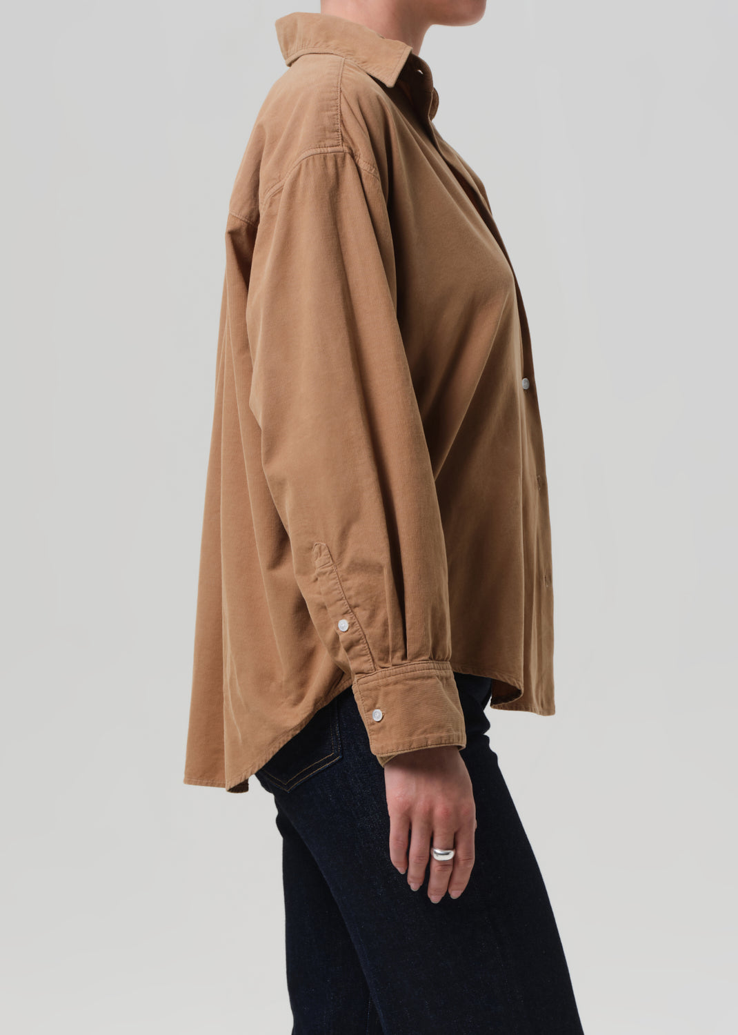 Brown corduroy shirt worn by a person on a grey background