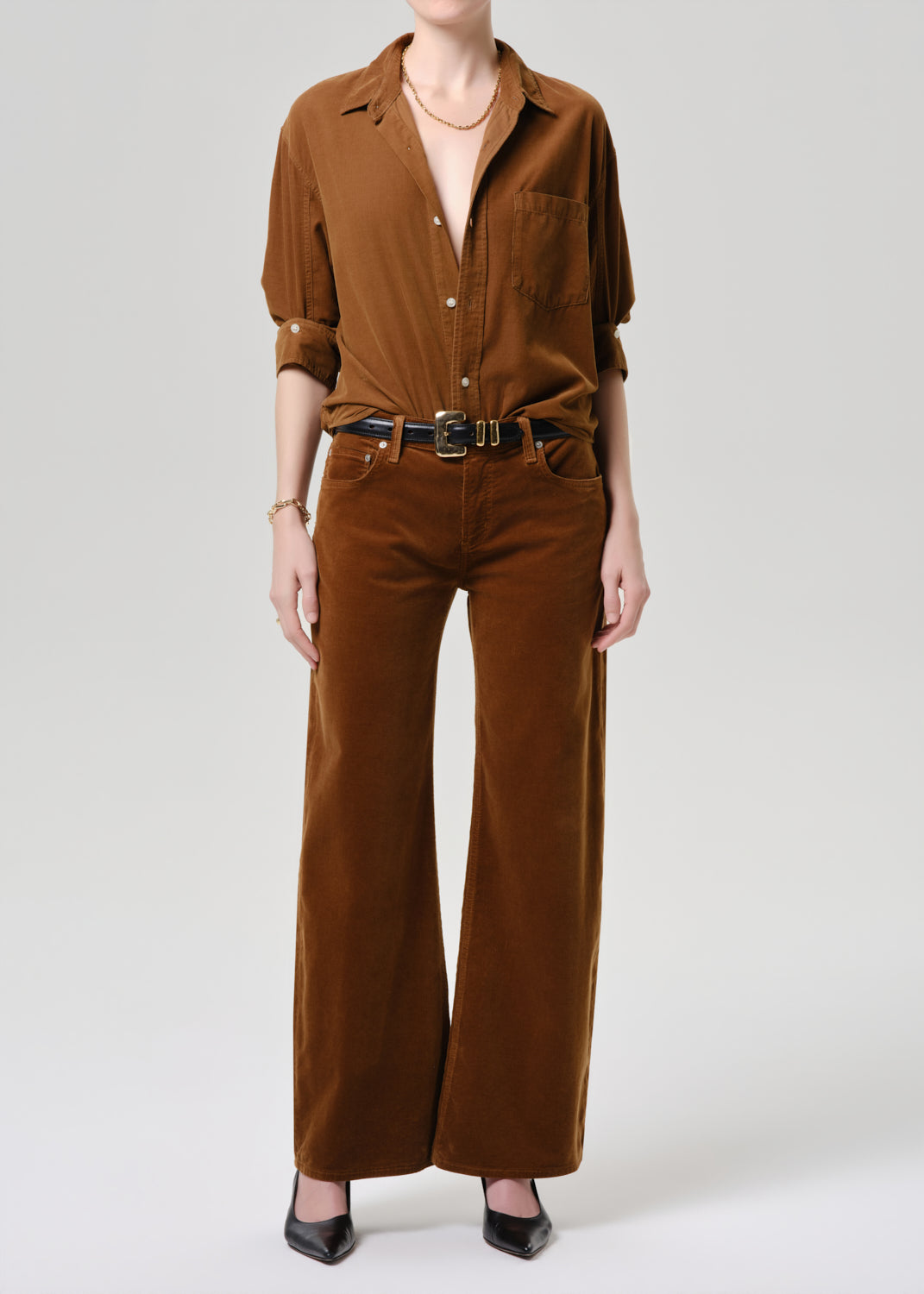 Person wearing a brown jumpsuit on a grey background