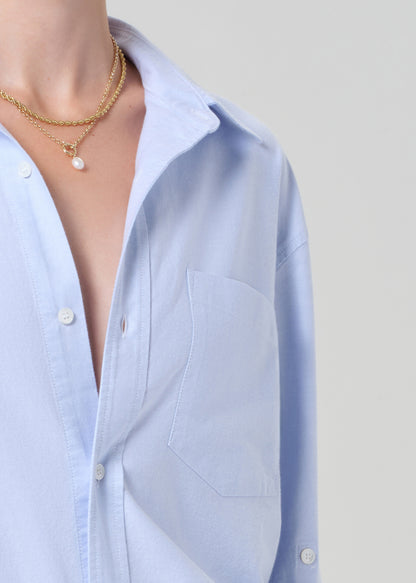 Light blue button-up shirt worn by a person on a plain background