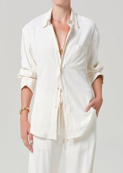 Person wearing an off-white shirt and pants on a gray background