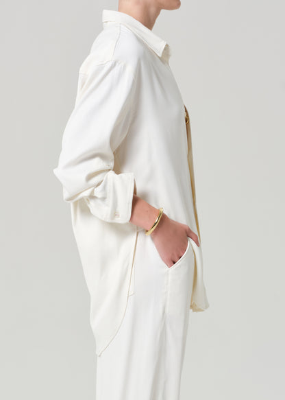 Person wearing an off-white shirt and pants on a gray background