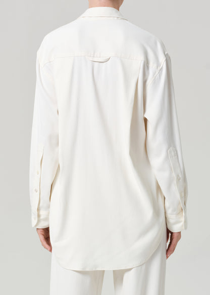 Person wearing an off-white shirt and pants on a gray background