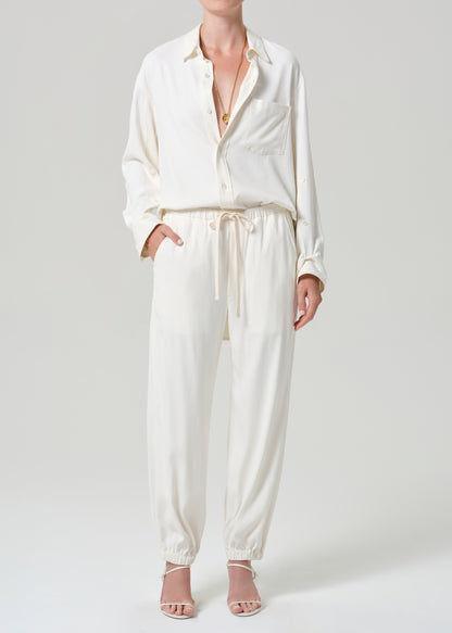 Person wearing an off-white shirt and pants on a gray background