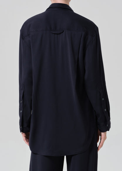 Person wearing a navy shirt and pants on a gray background