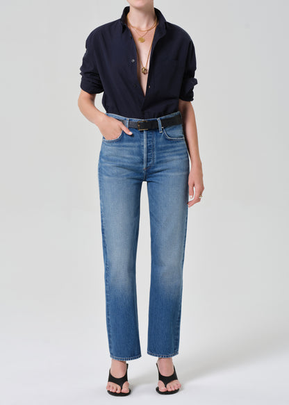 Person wearing a navy shirt and blue jeans on a plain background