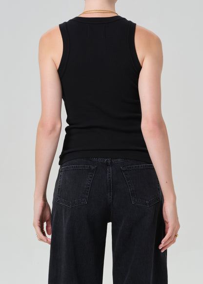 Person wearing a black sleeveless top and black pants on a light gray background